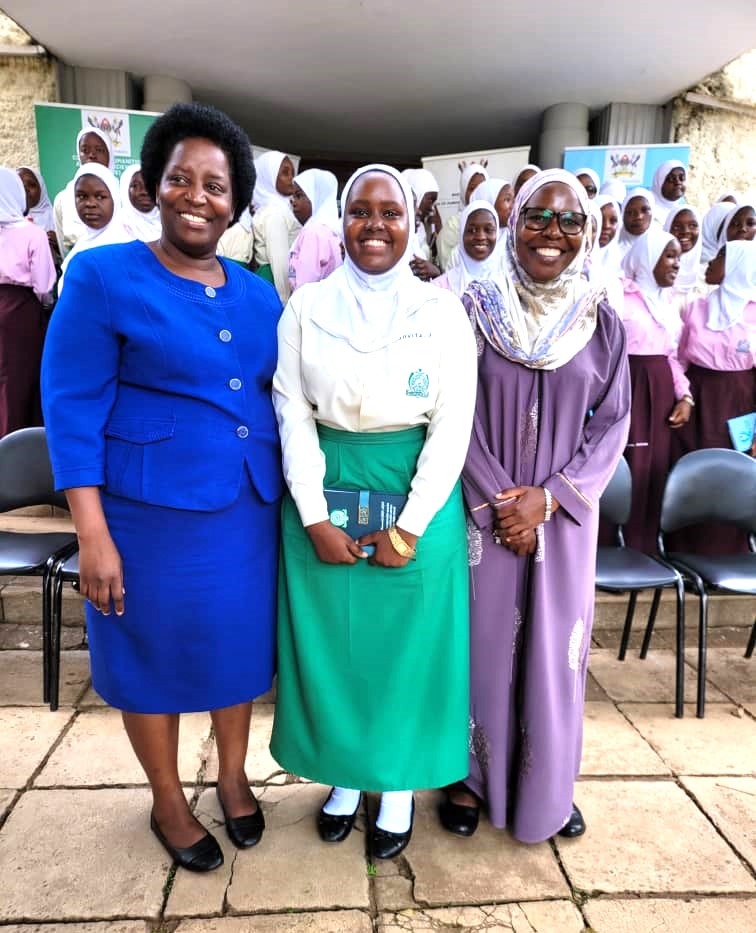 The Principal Assoc. Prof. Helen Nambalirwa Nkabala (L) and Dr. Dr. Aisha Sembatya Nakiwala HoD Journalism and Communication (R)  posing for a Photo with a student from Mbogo High School 