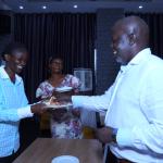 Dr Susan Kiguli serves cake to the HoD Literature Department Dr Edgar Nabutanyi