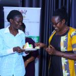 Dr Suzan Kiguli serves cake to the Principal Communication Officer of CHUSS Mrs Jane Anyongo
