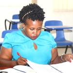 Internal Auditor Winnie Mbabazi going through the hand over report