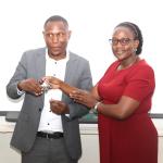 Ms. Joseline Biganja (R) handing over the office keys to Mr. Micheal Mbaine