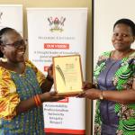 Ms. Prossy Nakayiki (R) receiving the plaque on behalf of Prof. Julius Kikooma