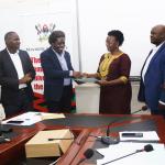 Prof. Patrick Mangeni (3rd) handing over to Dr. Pamela Khankwa (4th) witnessed by the college Human resorce officer and registrar on the left and the the Deputy pricipla and audit representative of the right
