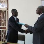 Prof Oswald Ndoleriire (R) hands over the principal mantle to Prof Edward Kirumira