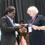 Prof. Patrick Mangeni receives a book from Prof. Marion Kuester of Rostock University